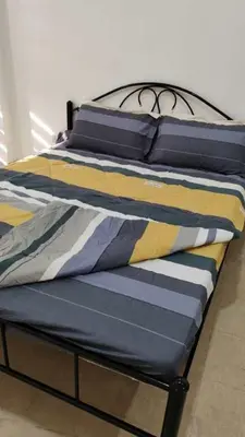 a bed with blue and yellow pillows on it at V hotel paranaque in Manila