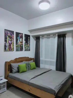 a bedroom with a large bed with green pillows at Sweet Kathleen at The Beacon Makati in Manila