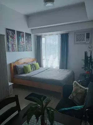 a bedroom with a bed and a window at Sweet Kathleen at The Beacon Makati in Manila