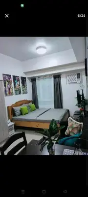 a bedroom with a bed and a table and chairs at Sweet Kathleen at The Beacon Makati in Manila