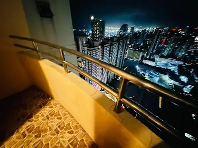 a balcony with a view of a city at night at Birch Tower a1 front of RobinsonMla Rizal Park in Manila