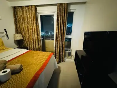 a bedroom with a bed and a window with a view at Birch Tower a1 front of RobinsonMla Rizal Park in Manila