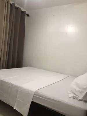 a small bedroom with a bed with white sheets at Birch Tower a1 front of RobinsonMla Rizal Park in Manila
