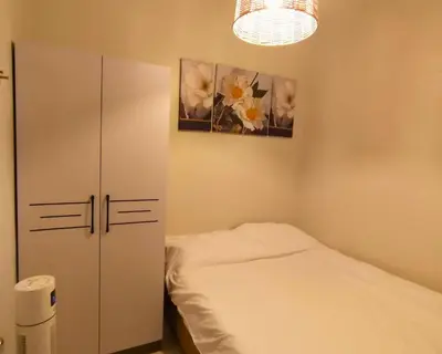a bedroom with a bed and a cabinet and flowers at ndulge in opulence on a budget near MOA! Luxuriate in our Deluxe 1 Bedroom Units with stunning views. Enjoy free NETFLIX and an exceptional discount. Book now for a lavish and affordable escape! in Manila