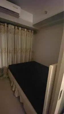 a bed in a room with a curtain at ndulge in opulence on a budget near MOA! Luxuriate in our Deluxe 1 Bedroom Units with stunning views. Enjoy free NETFLIX and an exceptional discount. Book now for a lavish and affordable escape! in Manila