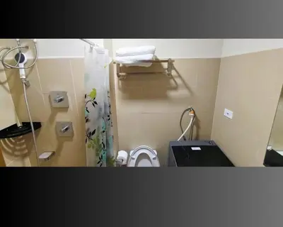 a small bathroom with a toilet and a shower at ndulge in opulence on a budget near MOA! Luxuriate in our Deluxe 1 Bedroom Units with stunning views. Enjoy free NETFLIX and an exceptional discount. Book now for a lavish and affordable escape! in Manila