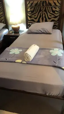 a bed with a blanket with flowers on it at 1BR Condo Unit W/ Fantastic View near US Embassy in Manila