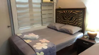a bedroom with a bed with flowers on it at 1BR Condo Unit W/ Fantastic View near US Embassy in Manila