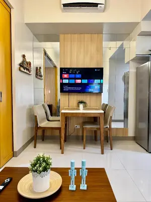 a dining room with a table and a tv at 1 BR Uptown BGC Cozy Condo Netflix 200Mb Wi-Fi in Manila