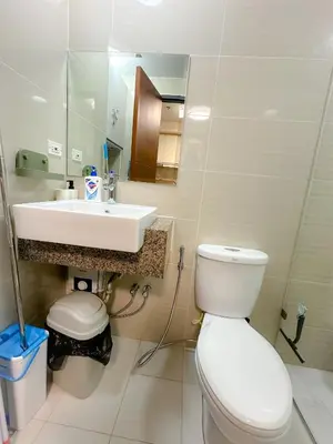 a bathroom with a white toilet and a sink at 1 BR Uptown BGC Cozy Condo Netflix 200Mb Wi-Fi in Manila