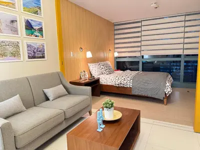a living room with a couch and a bed at 1 BR Uptown BGC Cozy Condo Netflix 200Mb Wi-Fi in Manila