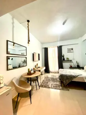 a bedroom with a bed and a table and a desk at Nature Inspired Cozy Studio Rooms Mandaluyong Near Edsa Shaw Shangri-La Megamall at F Residences in Manila
