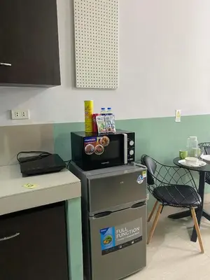 a kitchen with a microwave on top of a refrigerator at Nature Inspired Cozy Studio Rooms Mandaluyong Near Edsa Shaw Shangri-La Megamall at F Residences in Manila