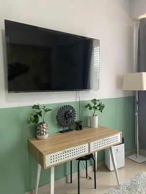 a tv on a wall above a table with plants at Nature Inspired Cozy Studio Rooms Mandaluyong Near Edsa Shaw Shangri-La Megamall at F Residences in Manila
