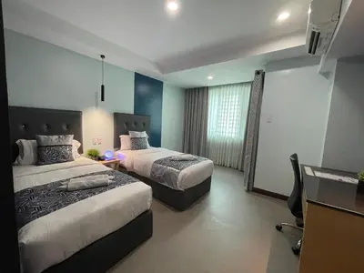a hotel room with two beds and a desk at Homes at Bay Area Suites by SMS Hospitality in Manila