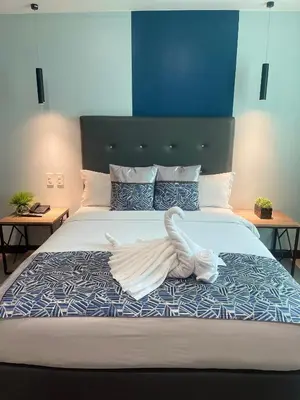 a large bed with a white swan laying on it at Homes at Bay Area Suites by SMS Hospitality in Manila