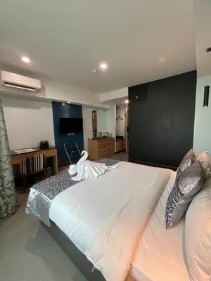 a bedroom with a large white bed with a black wall at Homes at Bay Area Suites by SMS Hospitality in Manila