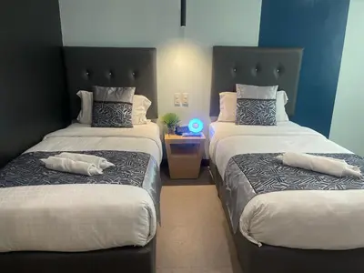 two beds with pillows on them in a room at Homes at Bay Area Suites by SMS Hospitality in Manila