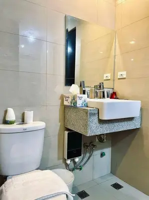a bathroom with a toilet and a sink at Thompson Suites - 2-beds near OKADA, Bayshore 2 in Manila