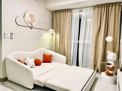 a living room with a white couch and a window at Thompson Suites - 2-beds near OKADA, Bayshore 2 in Manila