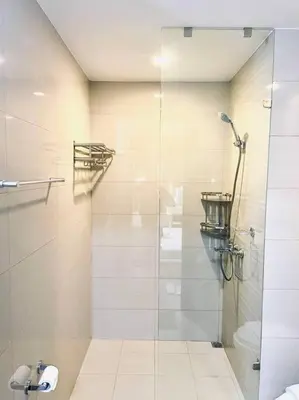 a bathroom with a shower with a glass door at Thompson Suites - 2-beds near OKADA, Bayshore 2 in Manila