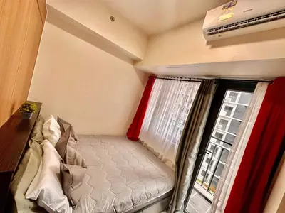a small bedroom with a bed next to a window at Apartment Seaside Bliss in Manila