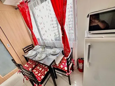a table and chairs in a room with a window at Apartment Seaside Bliss in Manila