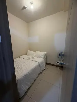 a small bedroom with a bed and a fan at SMDC Coast Residences - The Happy Place in Manila