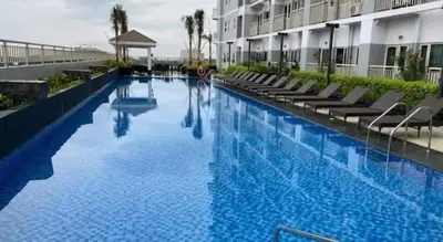 a large swimming pool next to a building at SMDC Coast Residences - The Happy Place in Manila