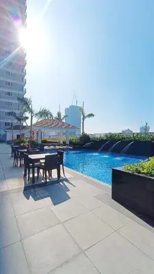 a table and chairs next to a swimming pool at SMDC Coast Residences - The Happy Place in Manila