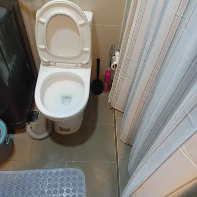 a bathroom with a toilet with the lid up at SMDC Coast Residences - The Happy Place in Manila