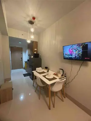 a living room with a table and a tv on the wall at Mall of Asia Shore 3 near Airport Pasay Manila 1 Bedroom Wifi in Manila