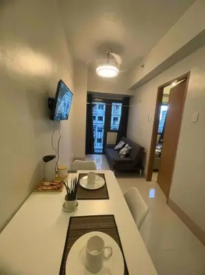 a living room with a table and a tv in a room at Mall of Asia Shore 3 near Airport Pasay Manila 1 Bedroom Wifi in Manila