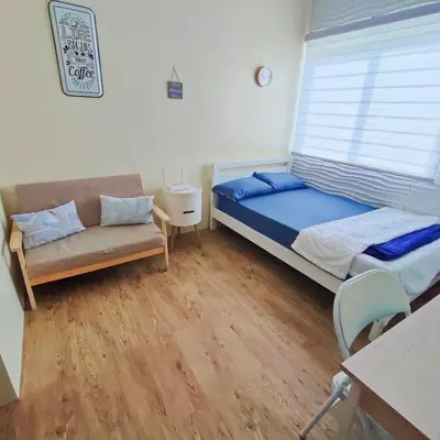 a bedroom with a bed and a couch and a window at Condo in Silang near Nuvali - Dy's Haven Suites in Silang