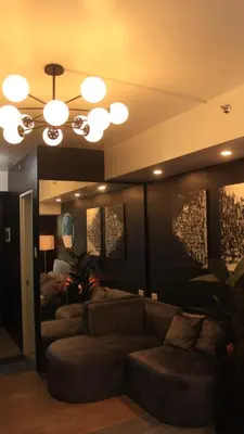 a living room with a couch and a chandelier at Avida Sucat Tower 9 in Manila