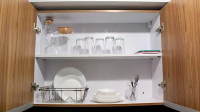 a cupboard filled with glasses and plates and dishes at Avida Sucat Tower 9 in Manila