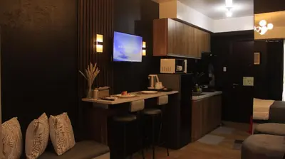 a kitchen with a bar with a tv on the wall at Avida Sucat Tower 9 in Manila