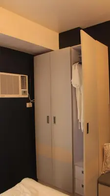 a bedroom with a closet and a fan at Avida Sucat Tower 9 in Manila