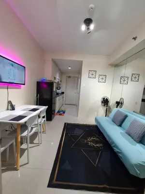 a living room with a bed and a table at Kings staycation at mall of asia in Manila