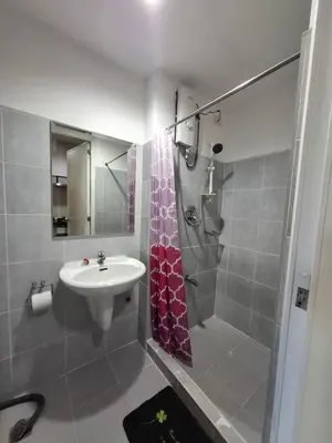 a bathroom with a sink and a shower at Kings staycation at mall of asia in Manila