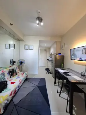 a living room with a couch and a table and a kitchen at Kings staycation at mall of asia in Manila