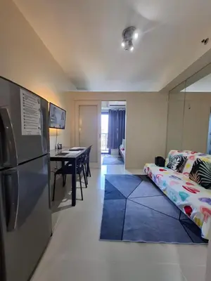 a kitchen and living room with a refrigerator and a table at Kings staycation at mall of asia in Manila