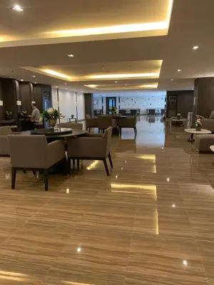 a lobby with tables and chairs in a building at TOP RATED 2026 Traveler Award Air Residences Manila Makati City Comfort and Style Budget Friendly Top rated prime location very short ride to and from airport in Manila