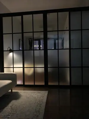 a living room with glass walls and a couch at TOP RATED 2026 Traveler Award Air Residences Manila Makati City Comfort and Style Budget Friendly Top rated prime location very short ride to and from airport in Manila