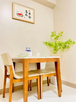 a dining room table with two chairs and a table at Thompson Suites Queen Room, One Uptown Residences, XBOX & Netflix in Manila
