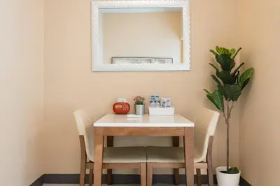 a table with chairs and a mirror on a wall at Thompson Suites Queen Room, One Uptown Residences, XBOX & Netflix in Manila