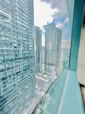 a view of a city from the top of a skyscraper at Thompson Suites Queen Room, One Uptown Residences, XBOX & Netflix in Manila