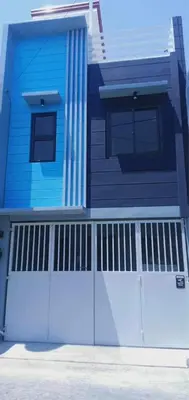 a blue house with a white garage door at Saphir Townhouse 5 to 6 pax rooftop terrace, Cavite in Imus