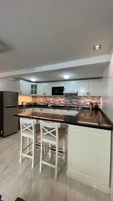 a kitchen with a large counter with stools in it at Saphir Townhouse 5 to 6 pax rooftop terrace, Cavite in Imus