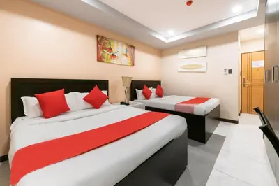 a bedroom with two beds with red and white pillows at AMORE HOTEL MANILA in Manila
